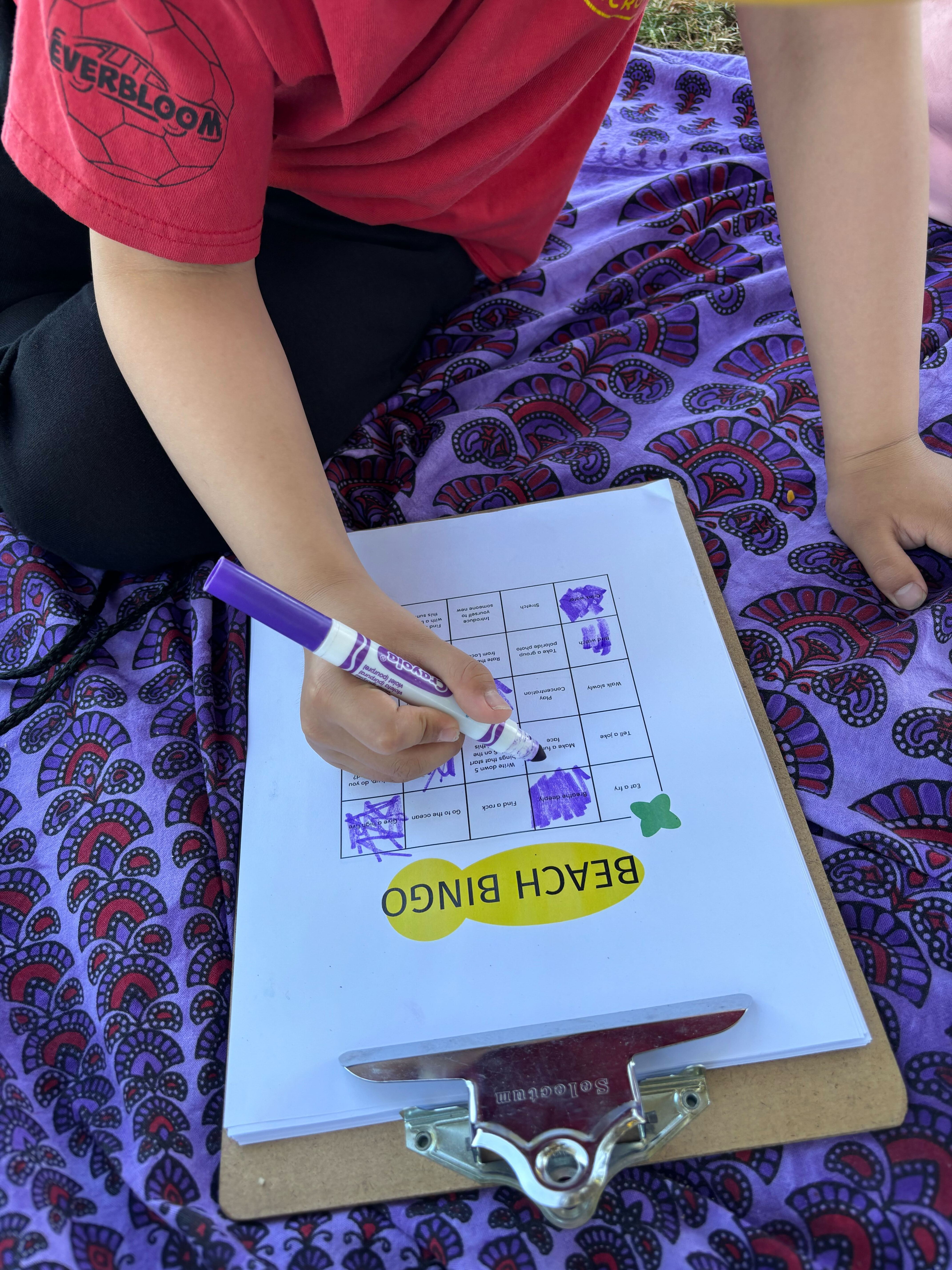 Close-up of a child's hands filling out an activity sheet