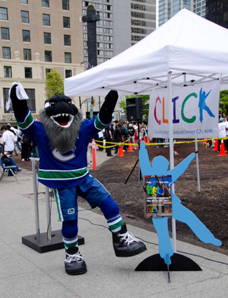 Fin poses beside a life-size cut-out of CLICK's Blue Boy under the CLICK tent