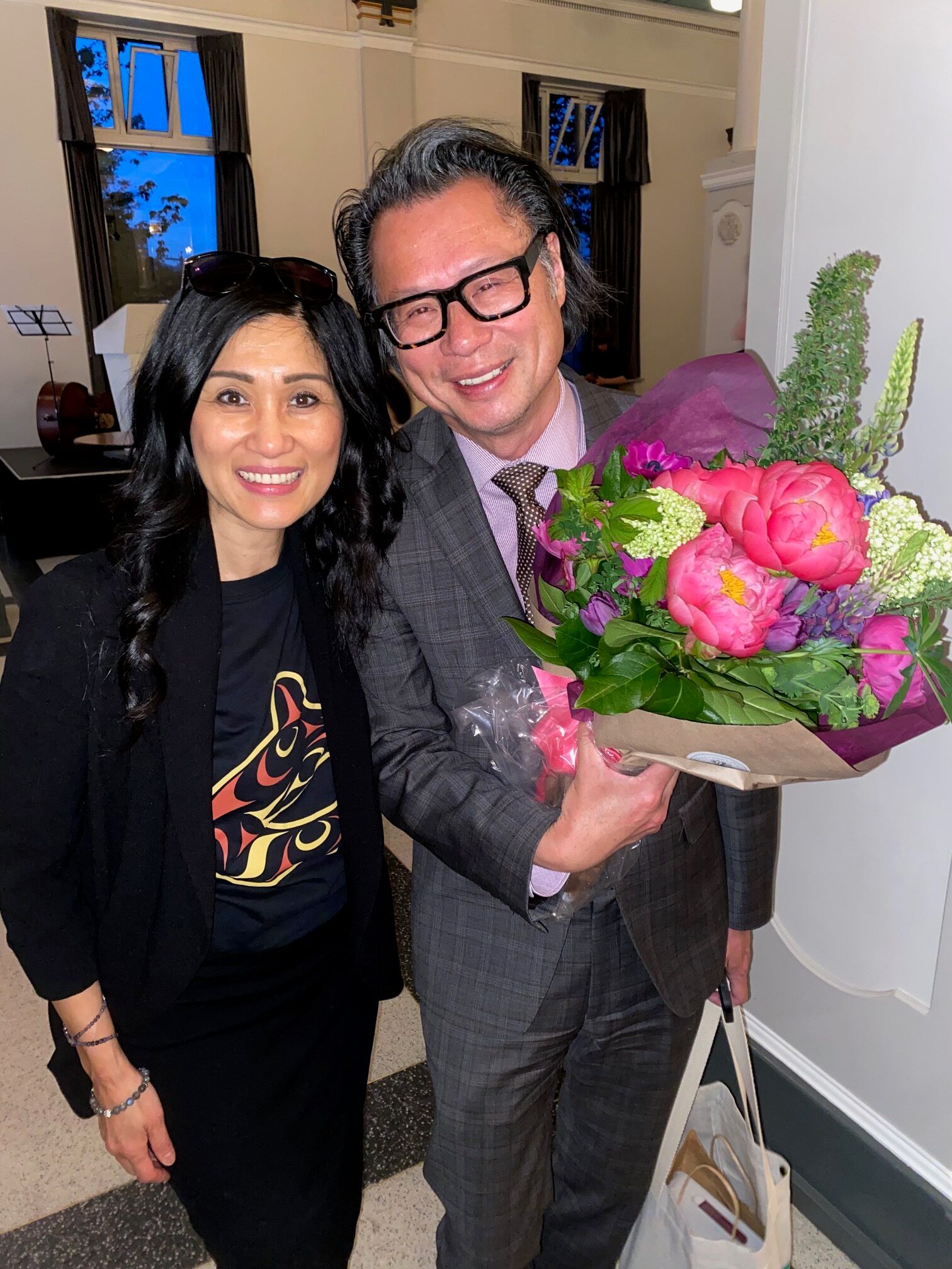 Janey Lee and Fred Lee posing for photo in formal wear, and Fred is holding flowers