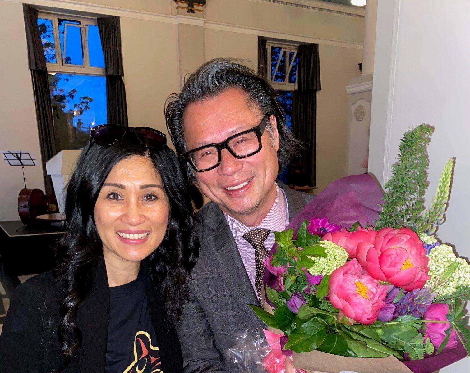 Janey Lee and Fred Lee posing for photo in formal wear, and Fred is holding flowers