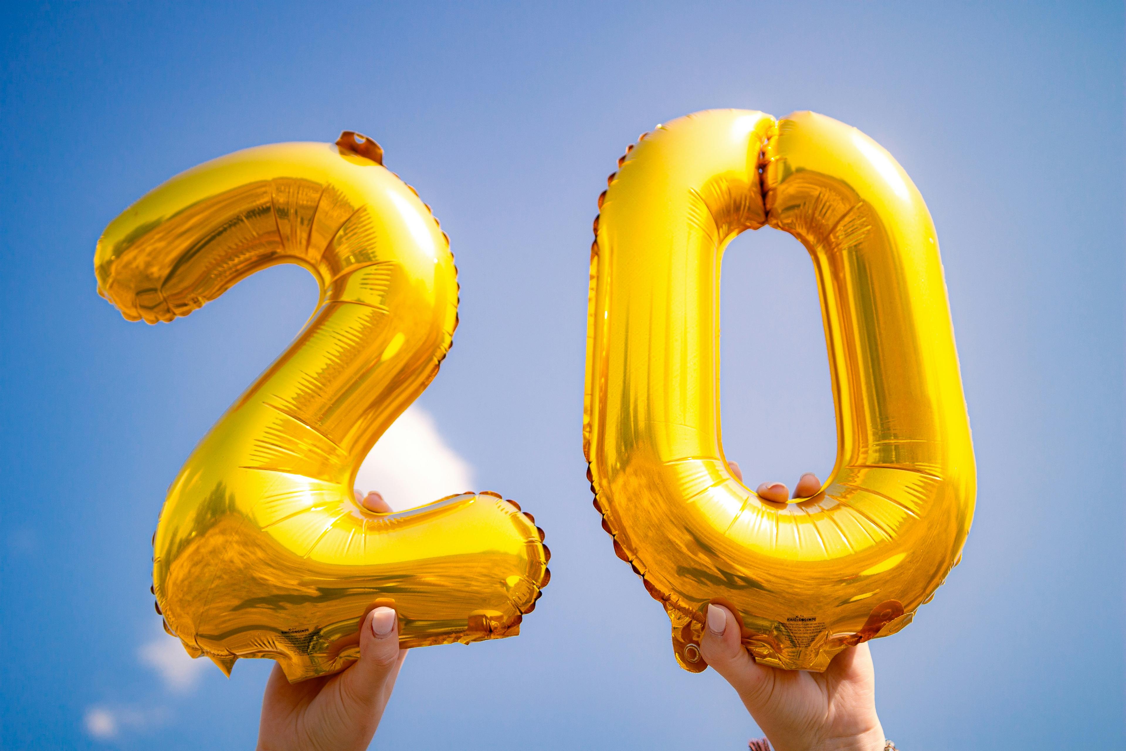 Golden balloons shaped like "20" lifted into the air