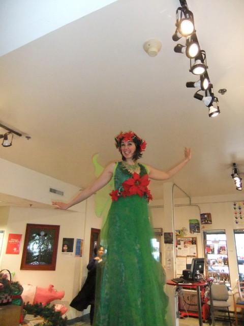 A stilt walker in a red and green costume towering over the room