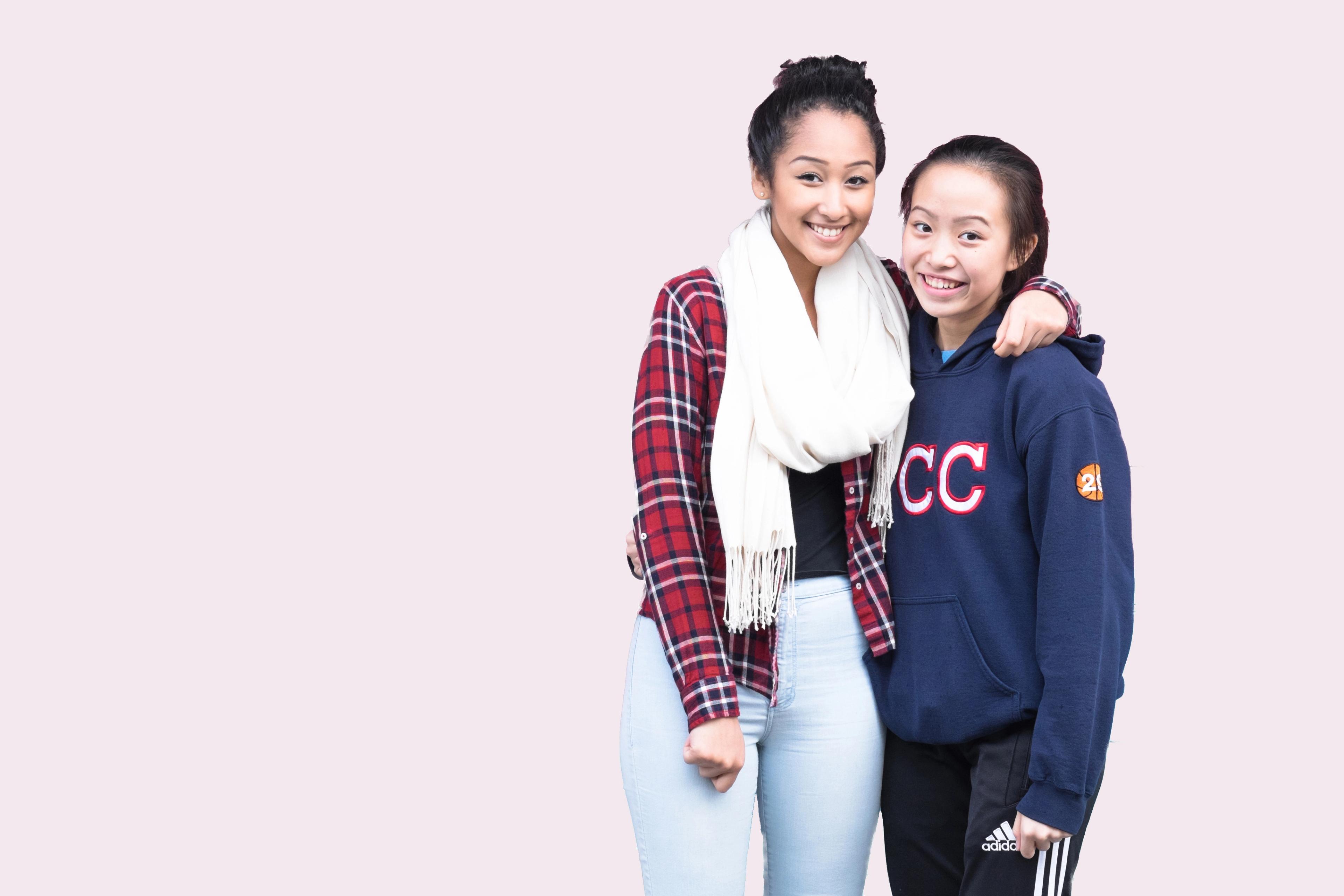 Two students in a CLICK photo booth, arms around each other