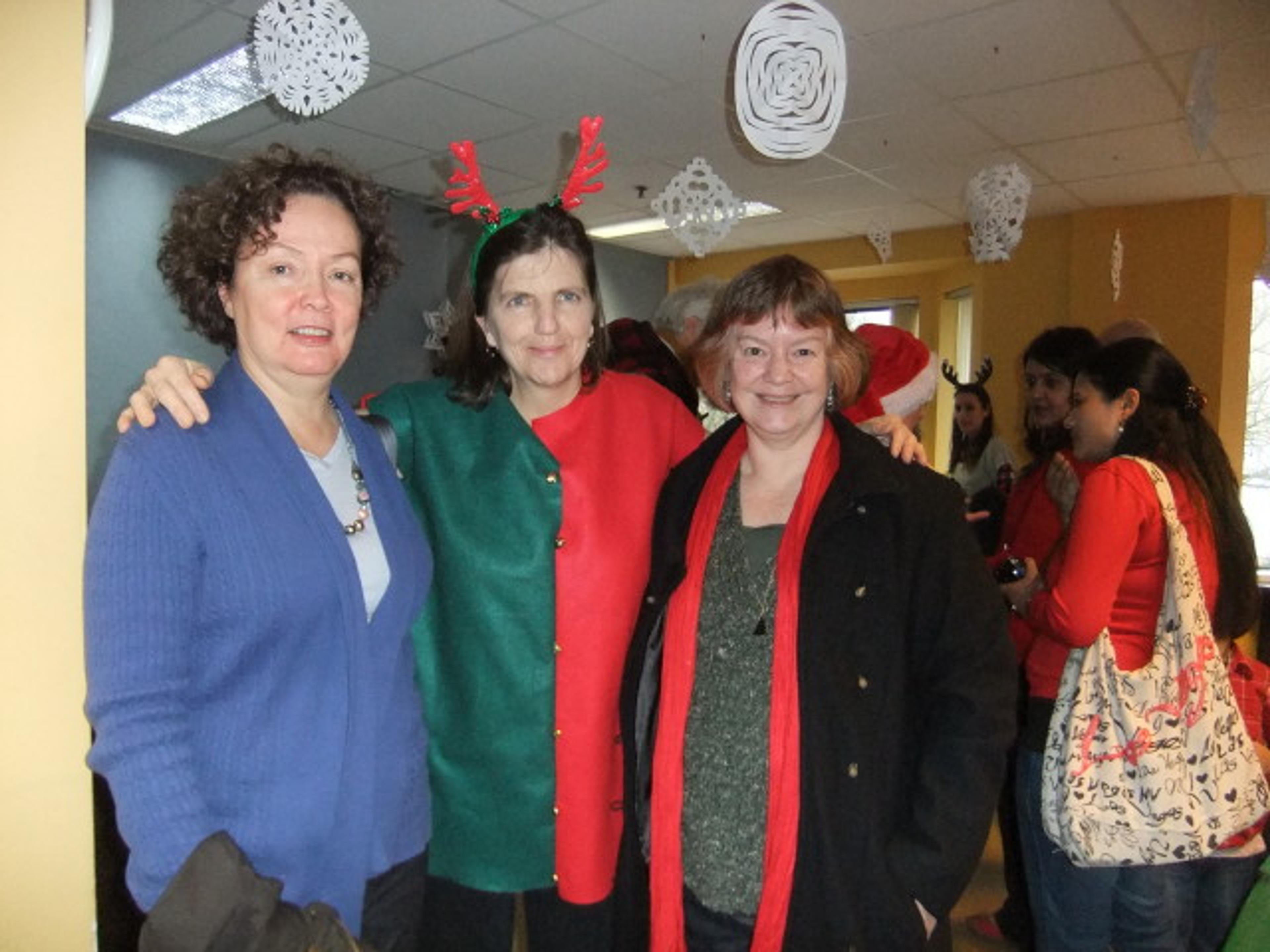 Three CLICK board members, two wearing elf hats, at the Winter Wonderland event