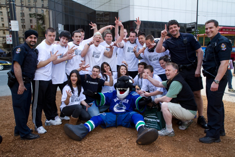 Students and police officers celebrate together with Fin lying on the ground in front of them
