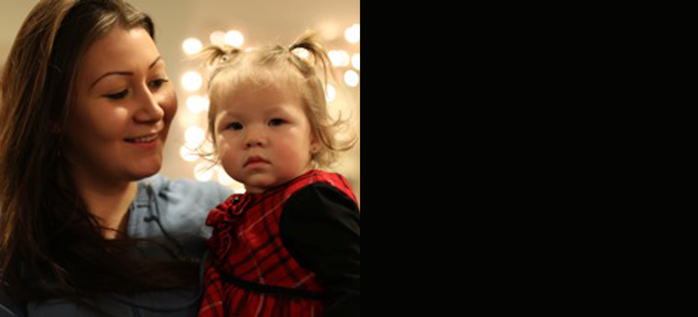 A young mother holding her toddler daughter, from the cover of CLICK's Spring 2014 newsletter