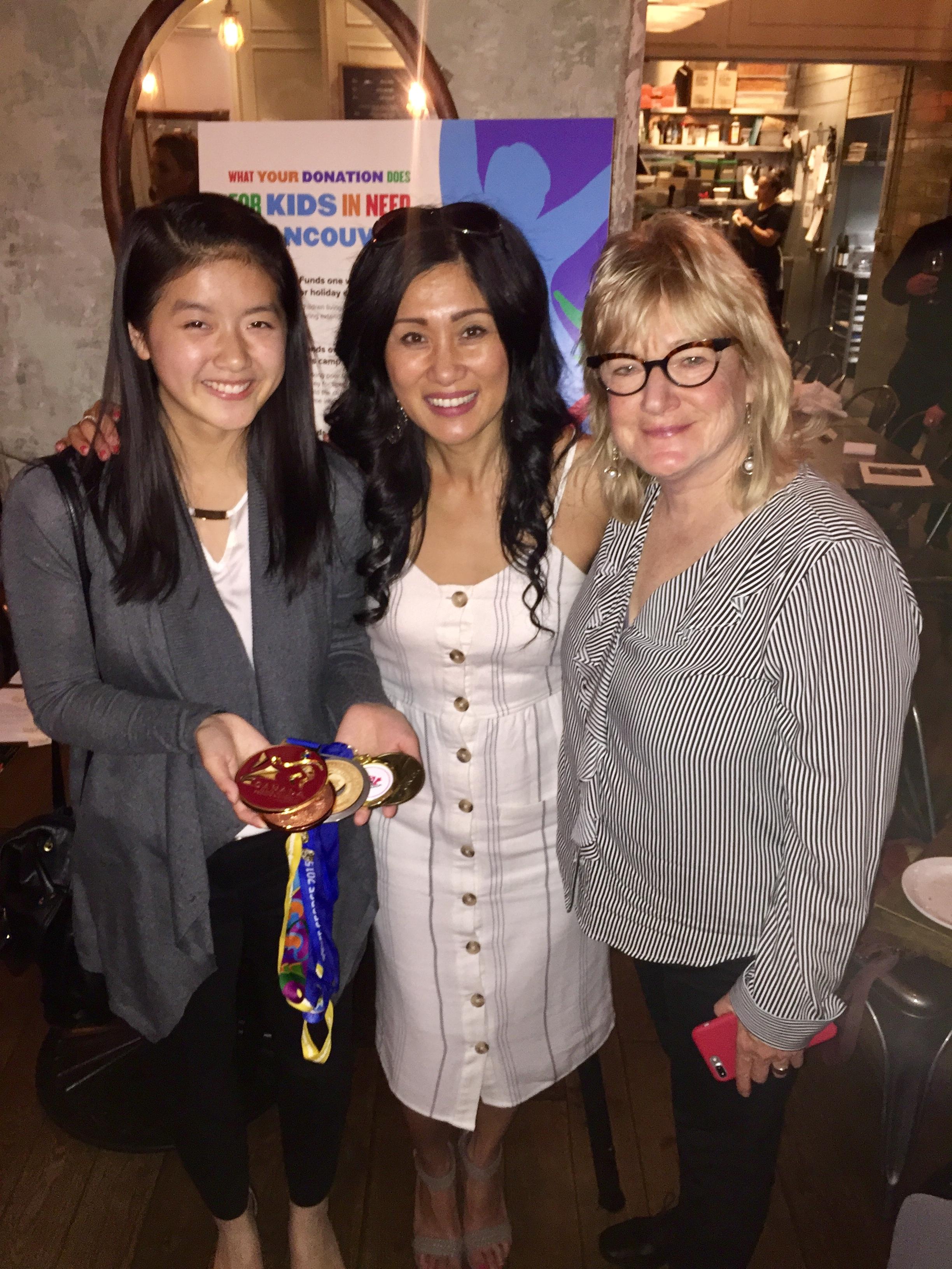 Three guests at the fifth annual Dinner to Make a Difference, holding auction paddles