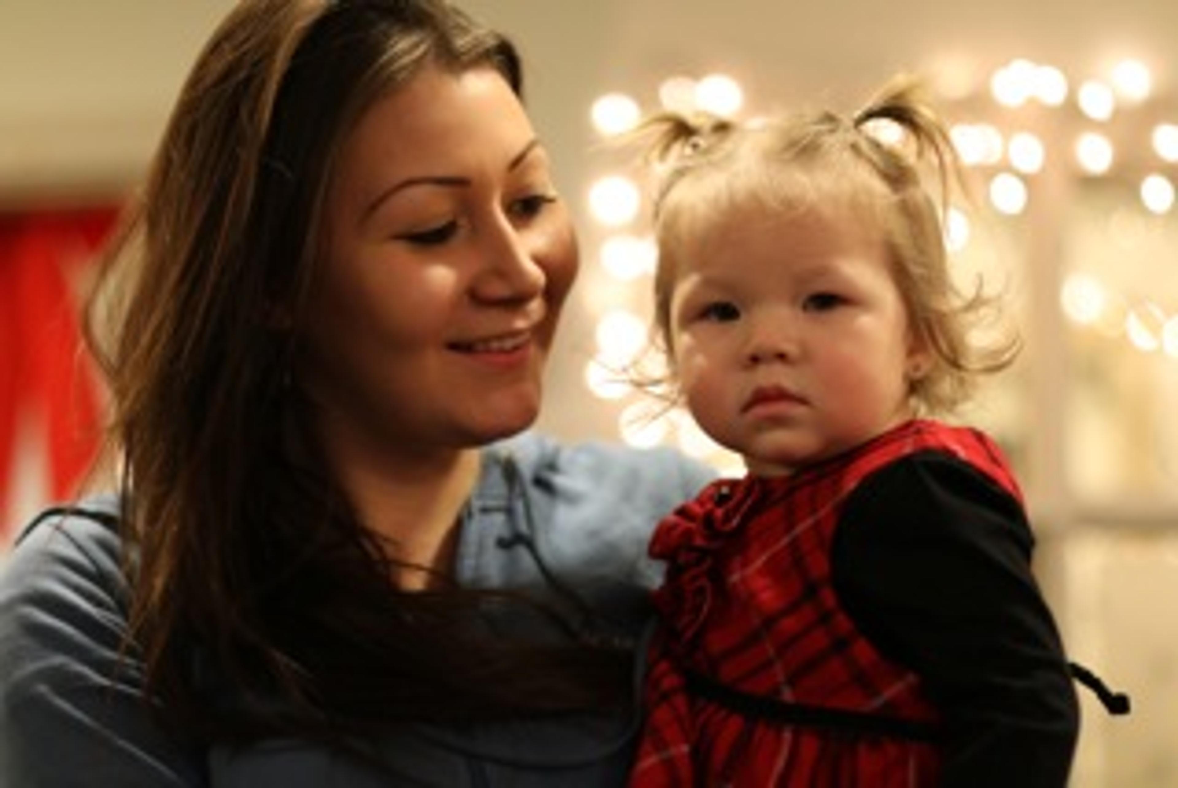 A young mother smiling with her baby on her lap