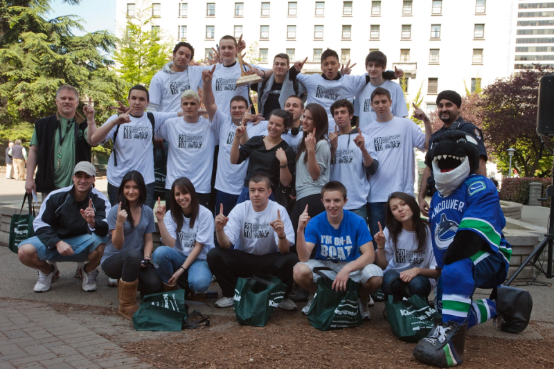 A large group of students, officers and volunteers pose together with Fin at the end of the day