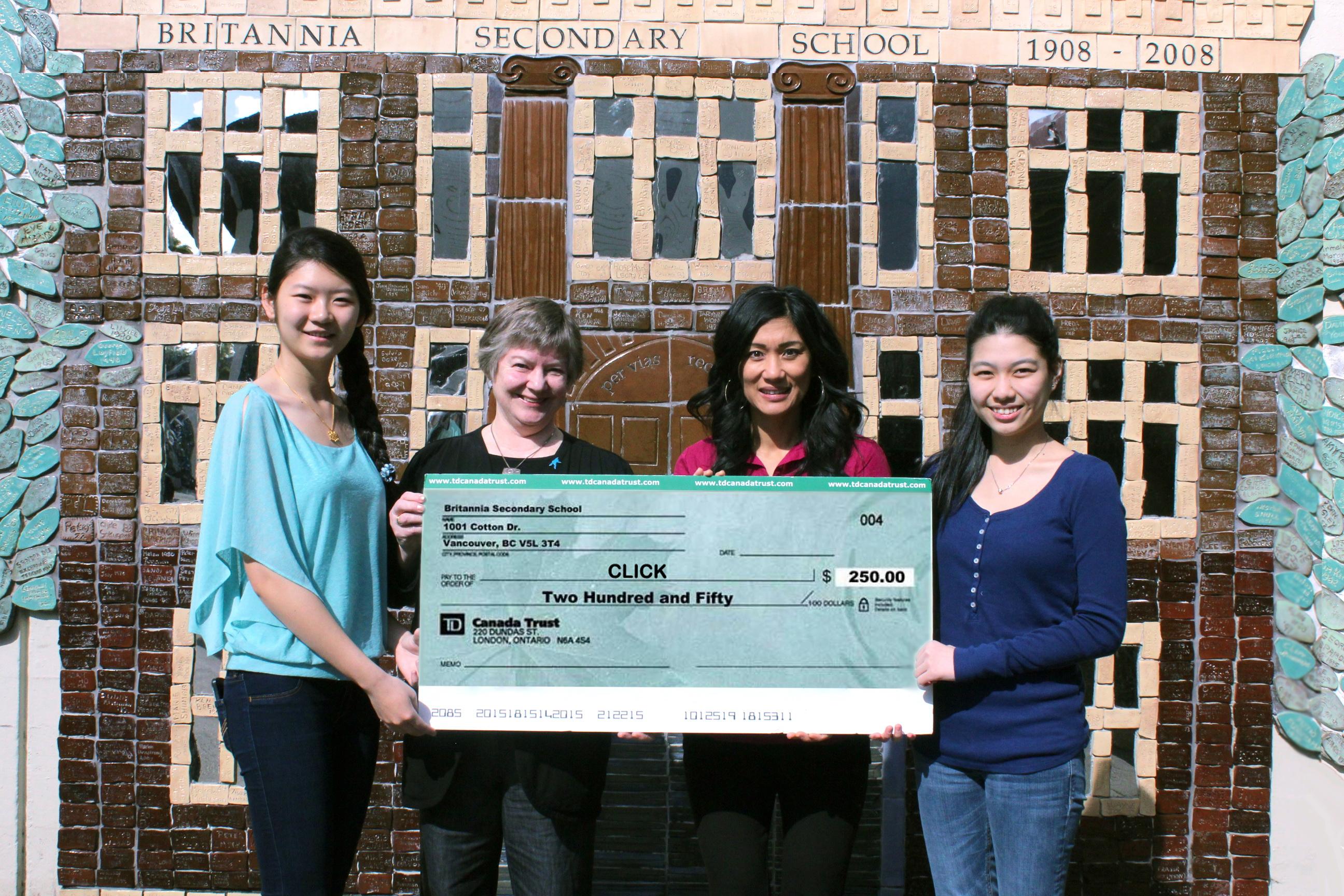 Students from Britannia Secondary's Business Club present an oversized cheque to CLICK board members outside the school