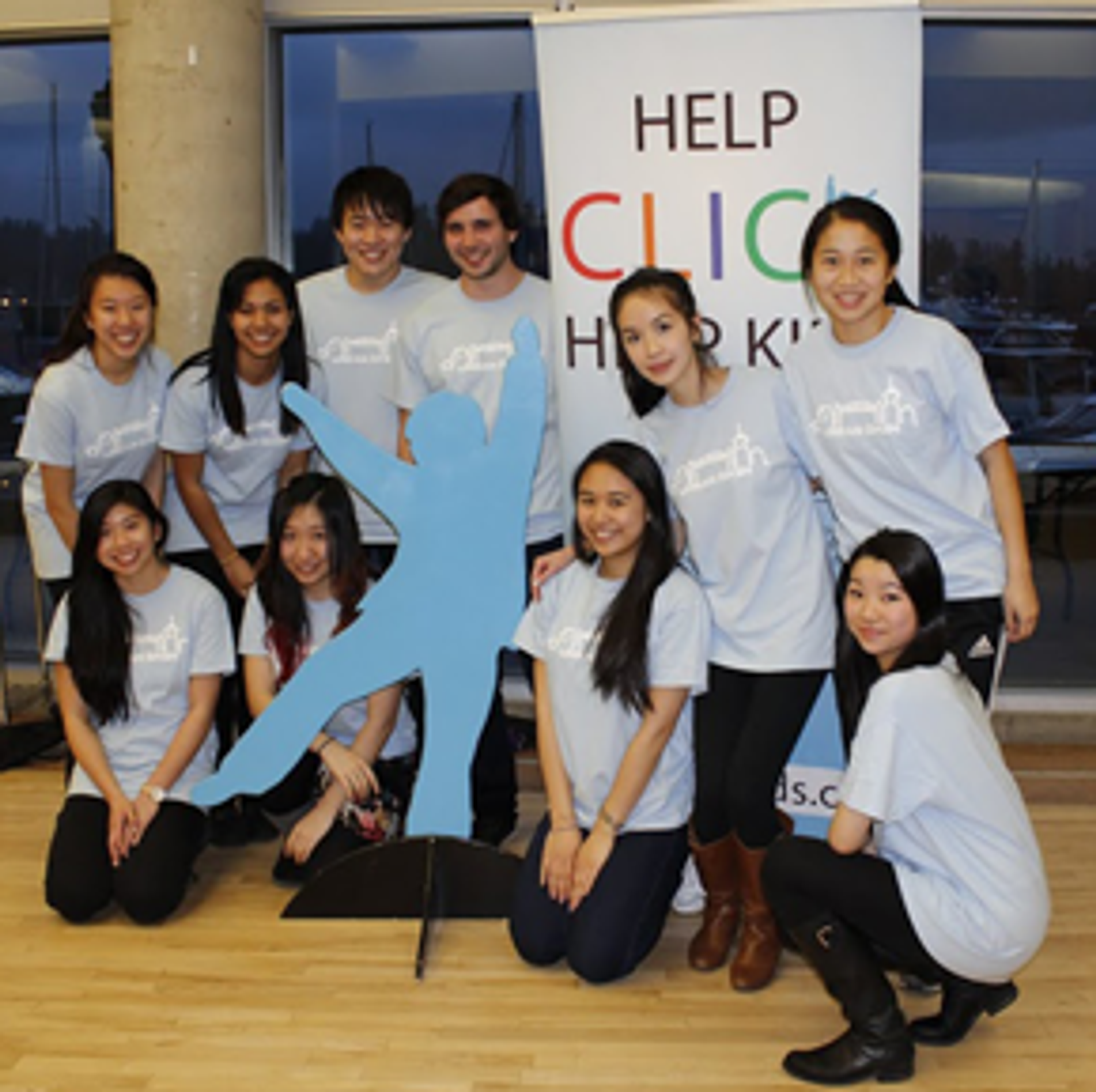 UBC Sauder marketing students in Help CLICK Help Kids T-shirts beside a Blue Boy cut-out