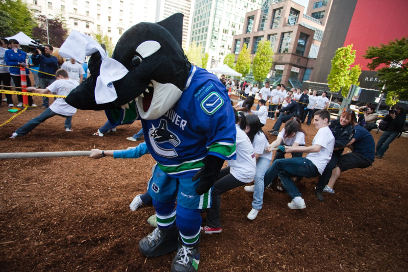 Fin takes hold of the rope in front of a line of students