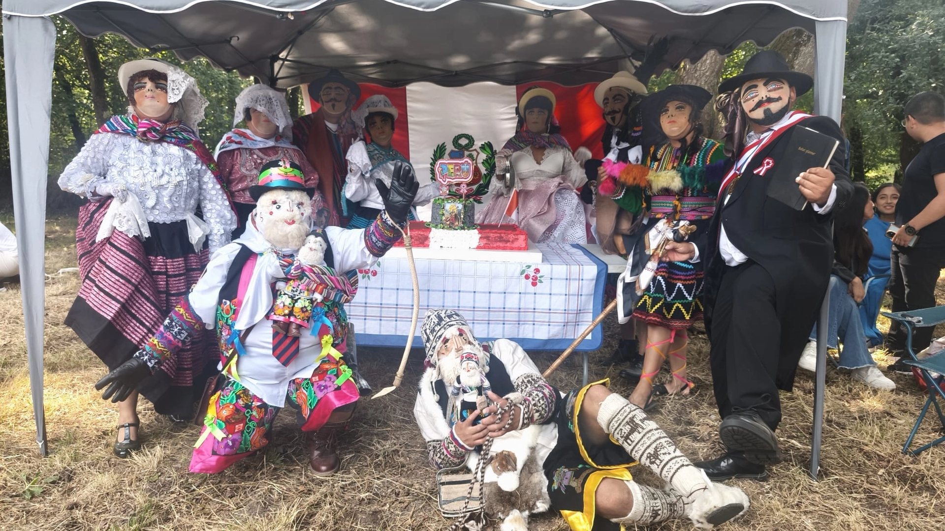 Integrantes de Sumaq Perú frente a una bandera del Perú durante las Fiestas Patrias en Oviedo