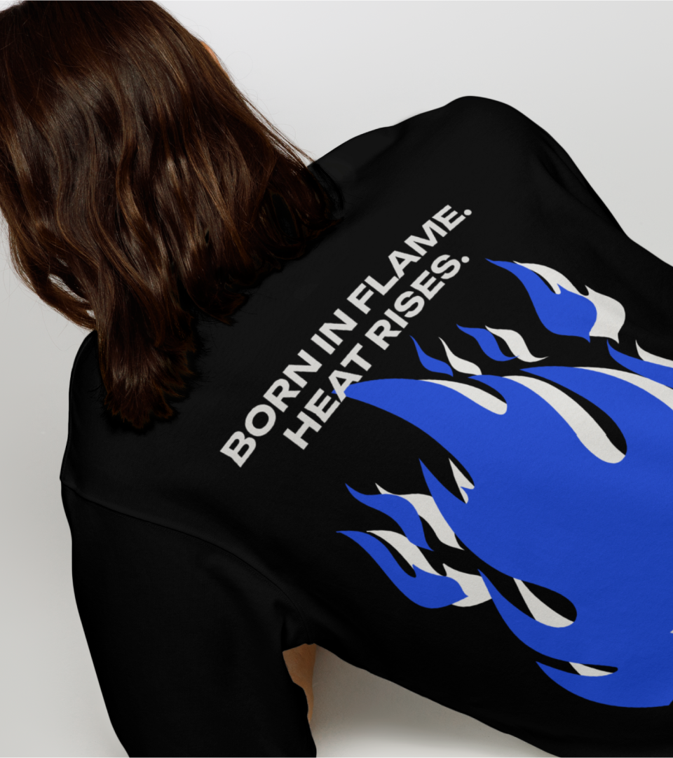 The back of a model's black top with blue flames and "Born in flame. Heat rises"