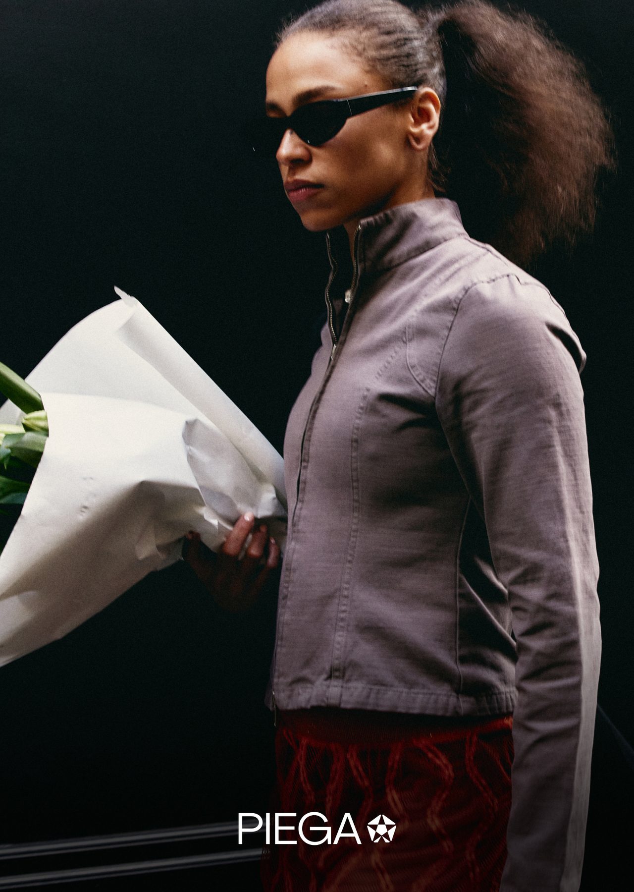 A woman holding flowers in a grey zip jacket