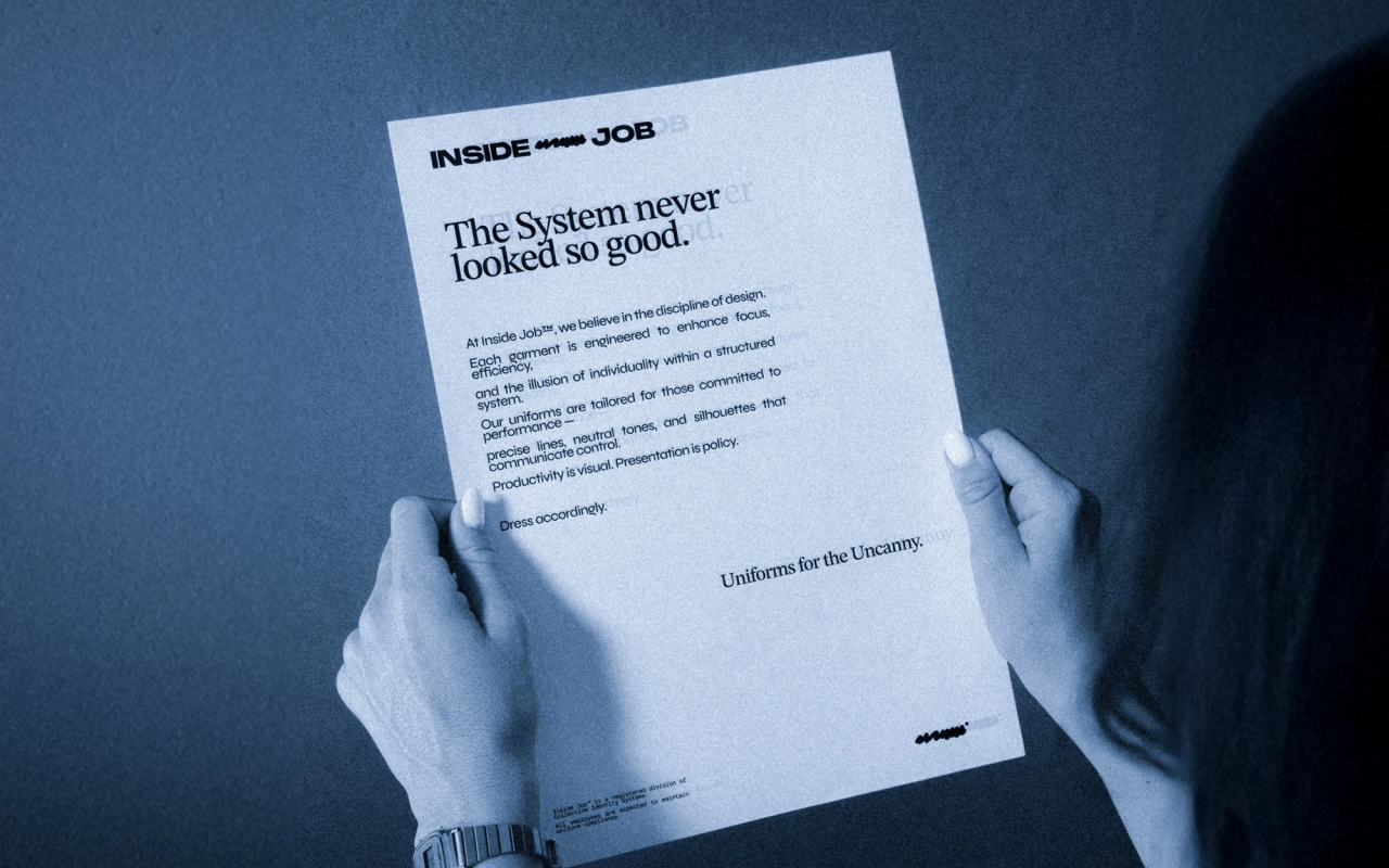 Hands holding an Inside Job letter that reads "The System never looked so good"
