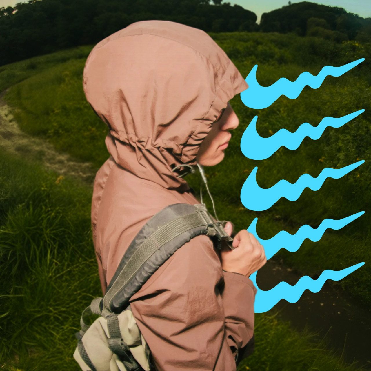 A hiker in a brown hooded jacket on a grassy trail beside five wavy blue swooshes