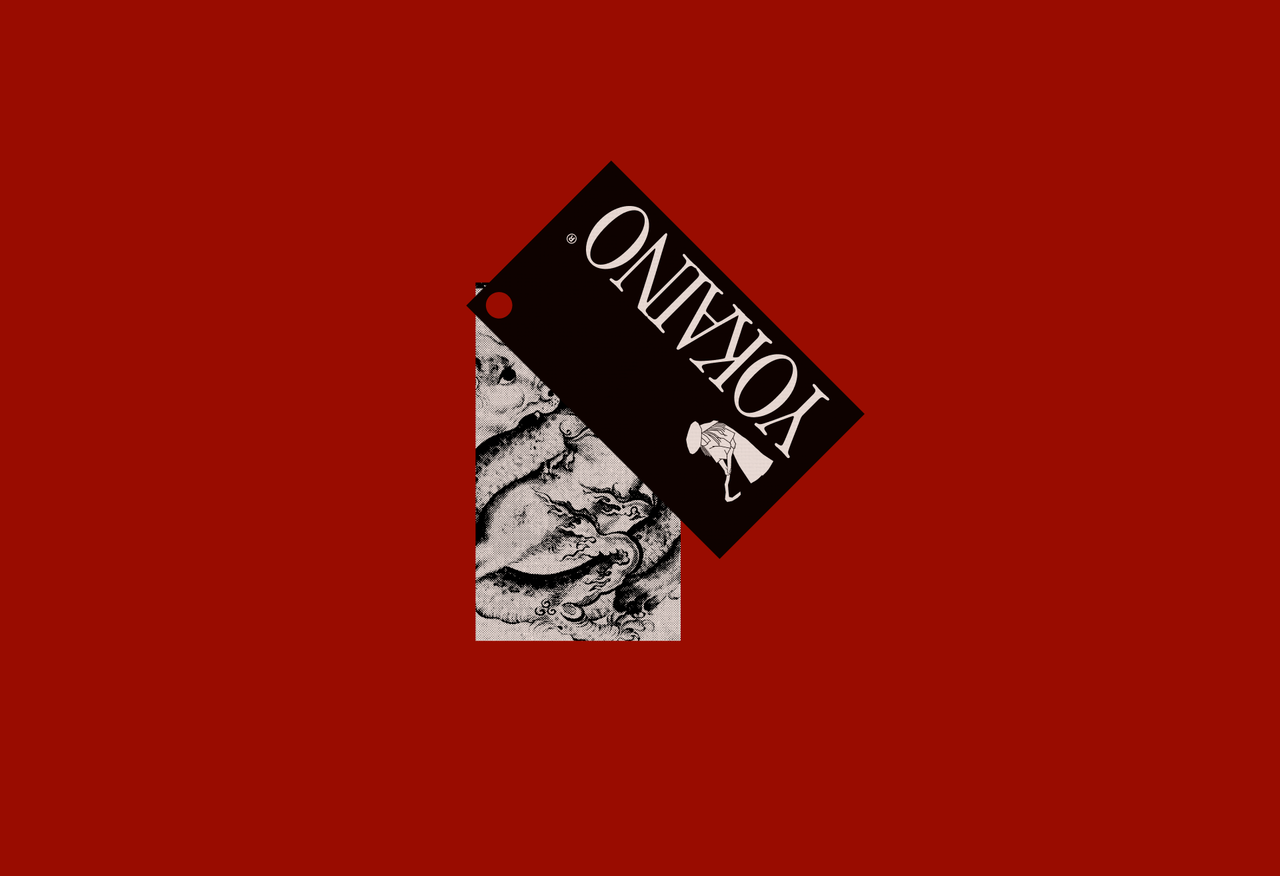 A black Yokaino hang tag over a second tag with an ink dragon, on red