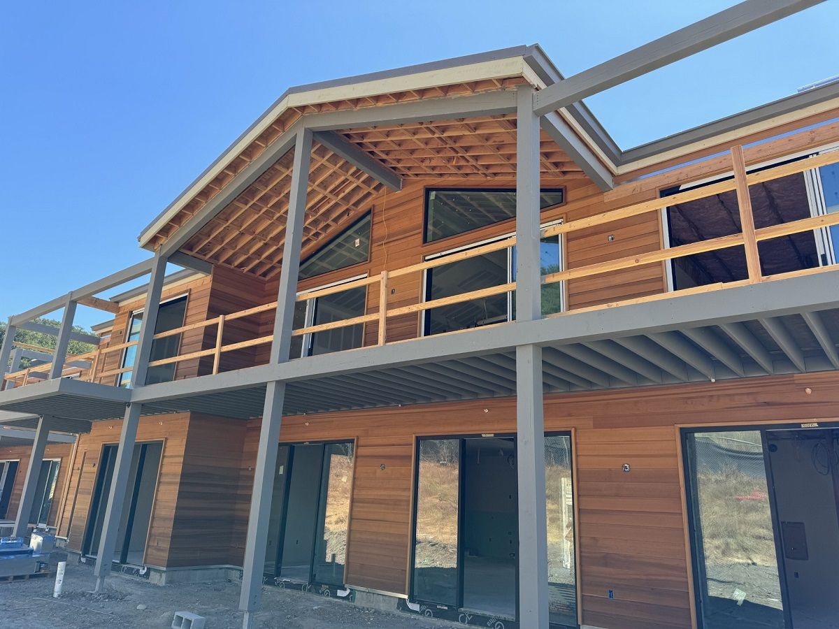 Exterior framing near completion with window and door installation shown