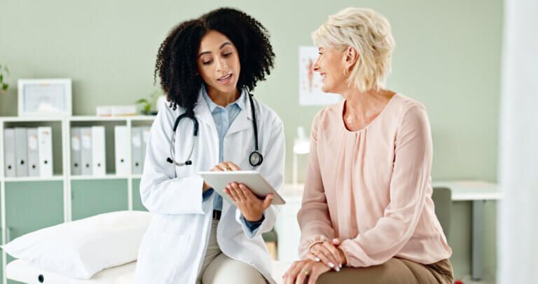 Point of Care engagement between a black female doctor and older caucasian female