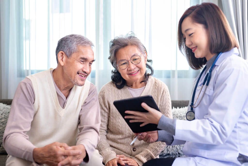 Senior couple got medical service visit from caregiver doctor at home while having result of medical exam for health care and pension welfare insurance
