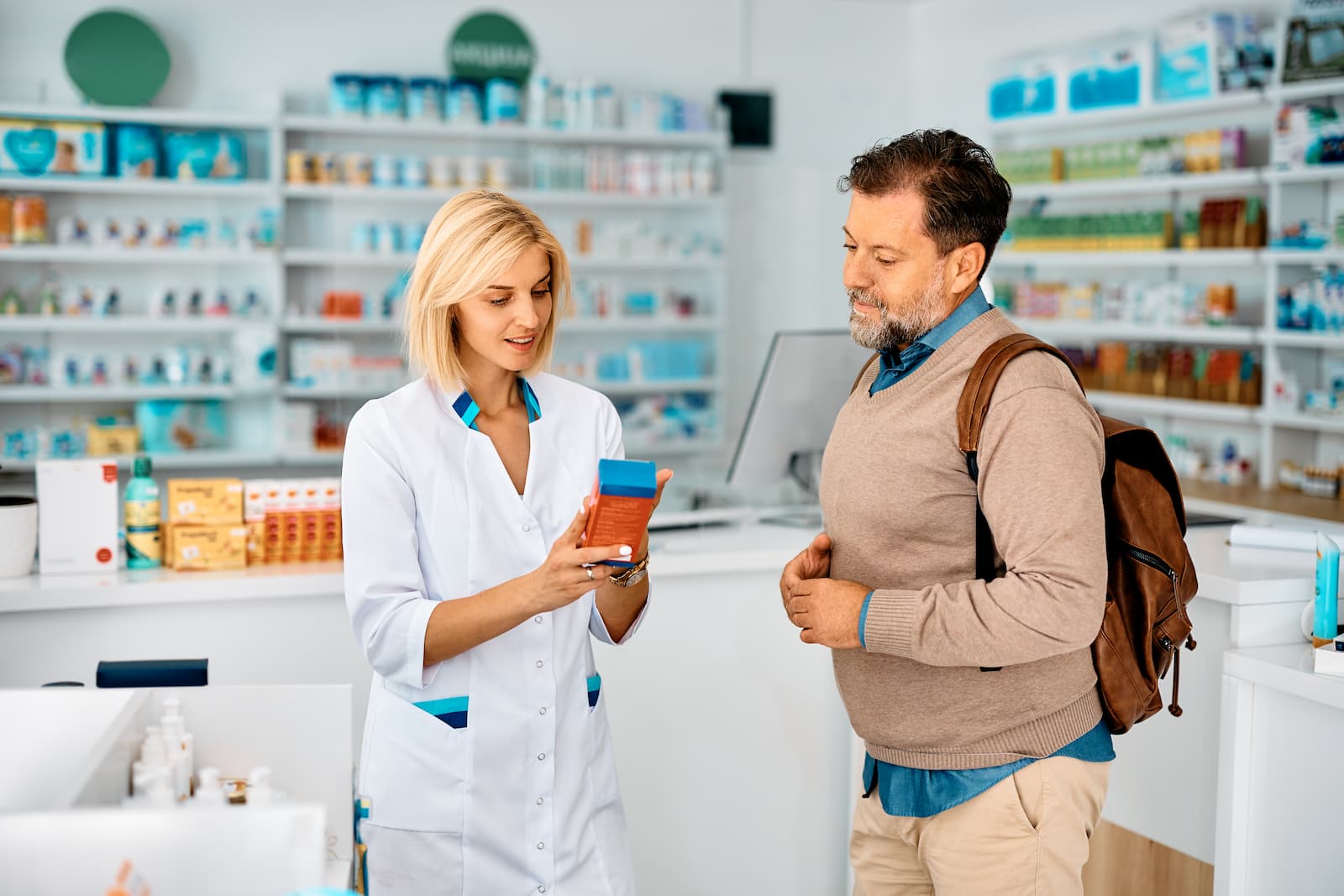 Pharmacist explaining a medication to a customer at a pharmacy counter