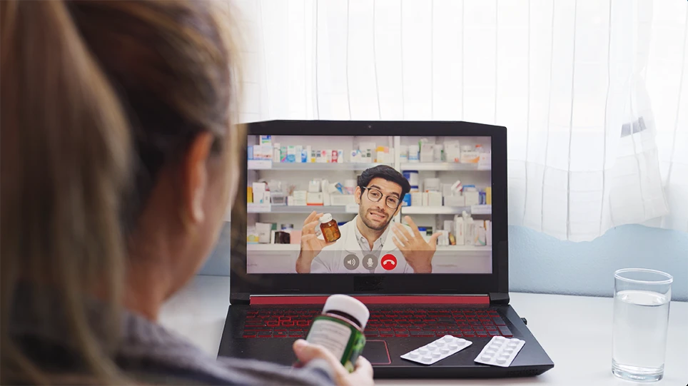 Patient on a video call with a pharmacist on a laptop