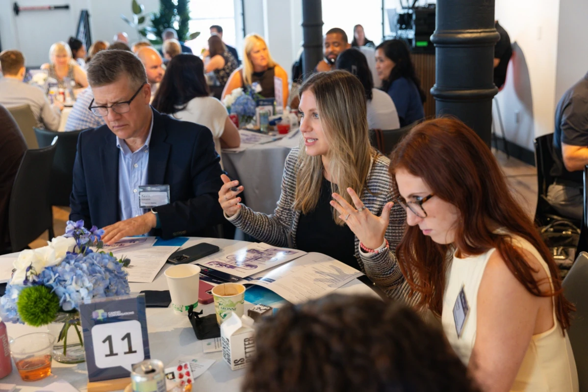 Attendees in discussion at a Candid Conversations table.