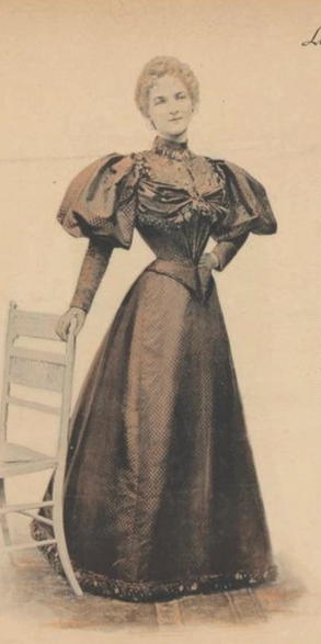 Afbeelding van vrouw met japon met ballonmouwen en sterk ingesnoerde taille, staand bij een stoel