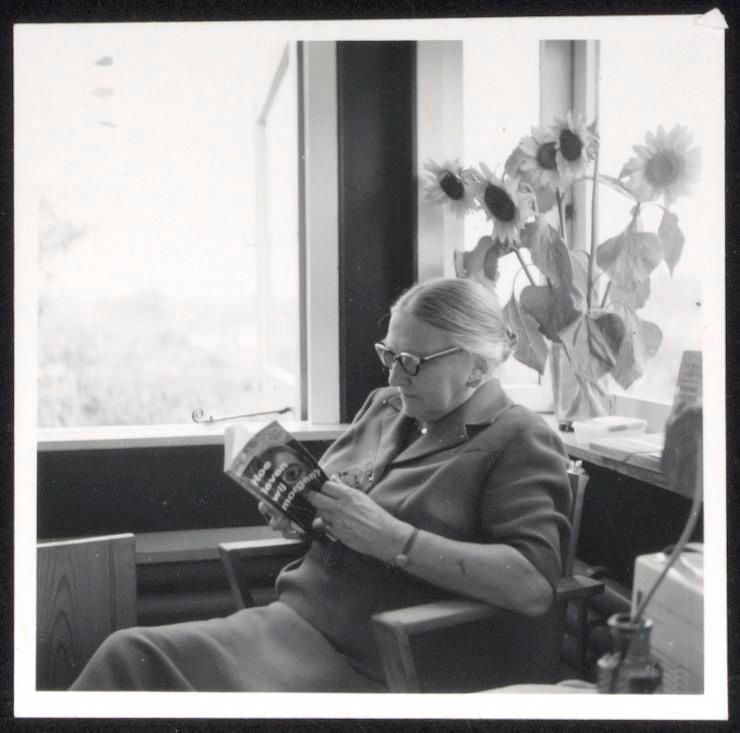 Zwart-witfoto van Truus Schröder, lezend in een stoel in het Rietveld Schröderhuis