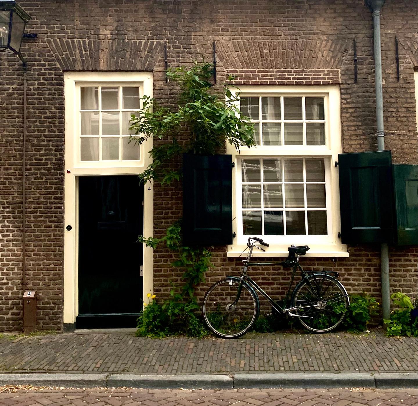 Een foto van de voorkant van een huis met aan de linkerkant de voordeur en rechts een raam.