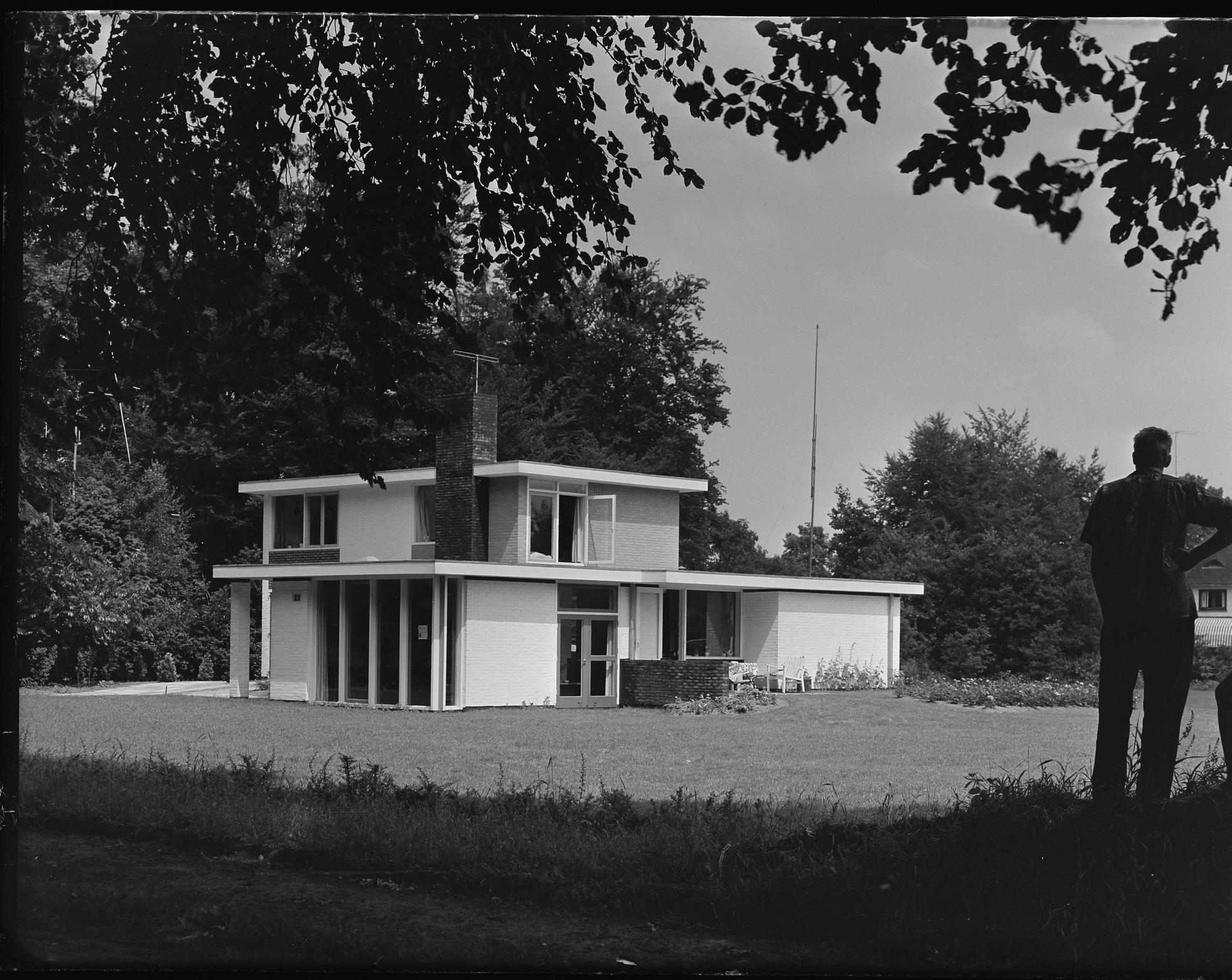 Detached two-storey house with a flat roof. White façades.
