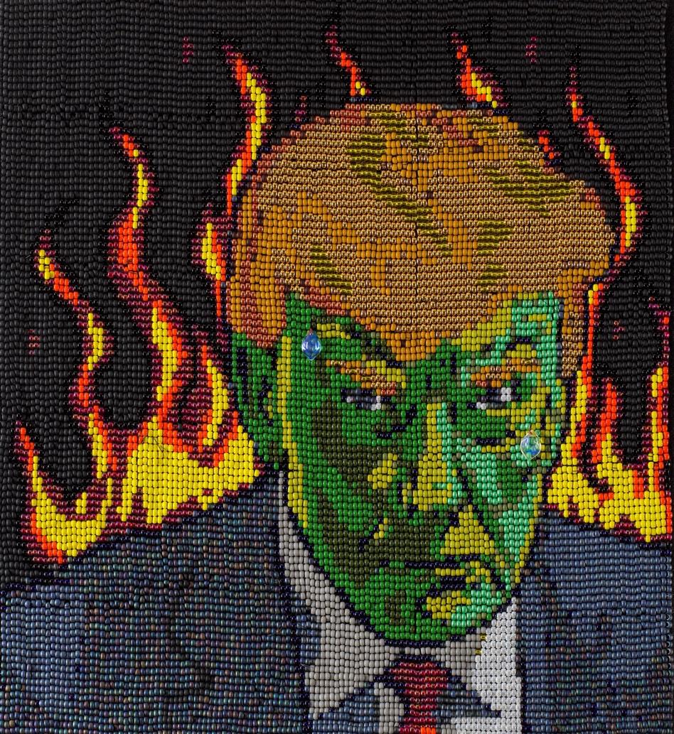 Een geborduurd portret van Donald Trump met een groen gezicht, omringd door vlammen.