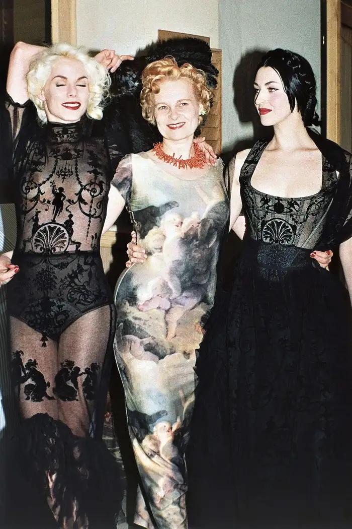 Model and fashion designer backstage at a fashion show.