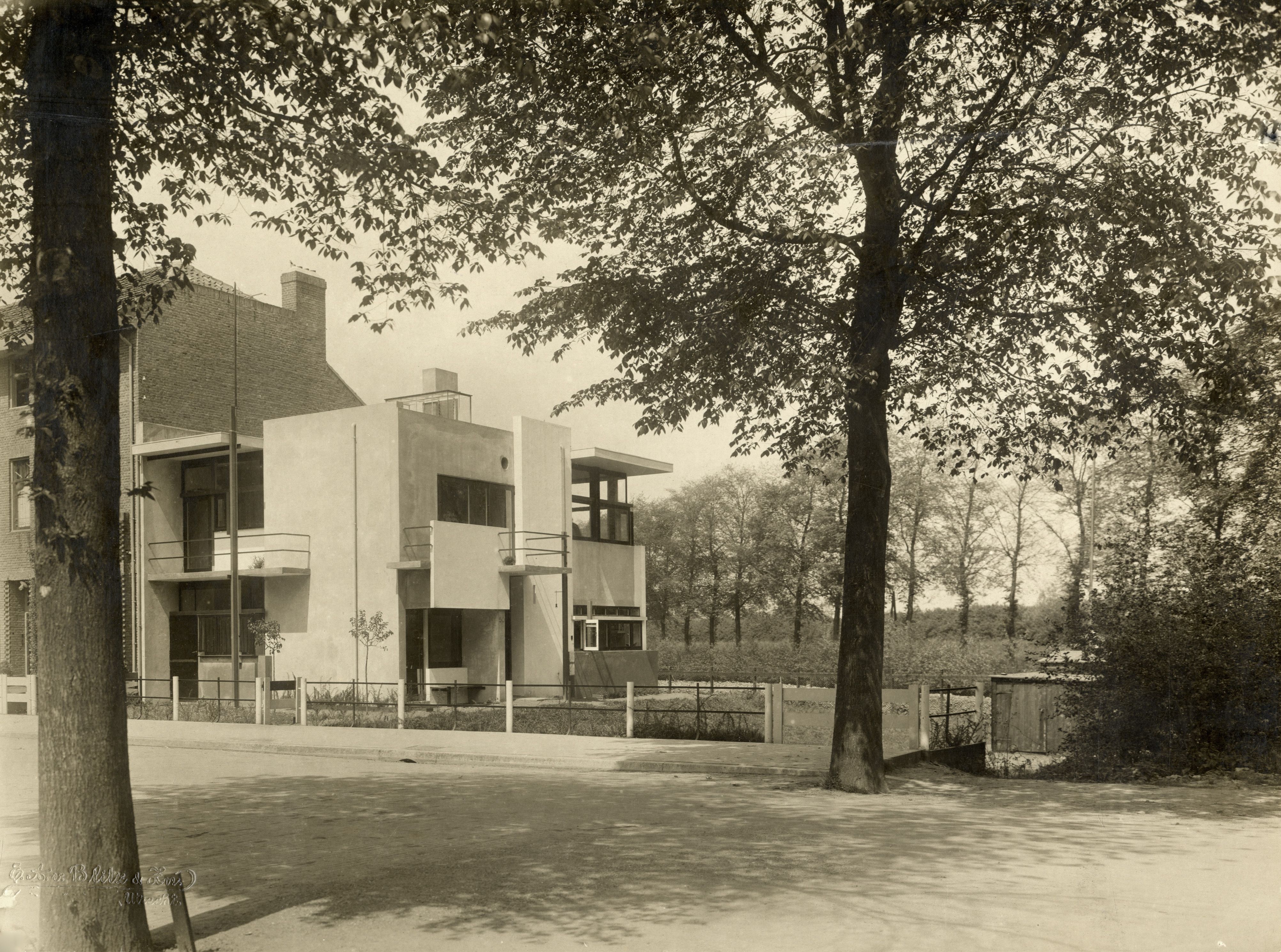 Zwart-witfoto van het Rietveld Schröderhuis, omgeven door bomen