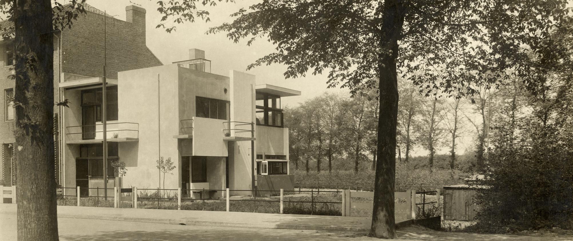Zwart-witfoto van het Rietveld Schröderhuis, omgeven door bomen