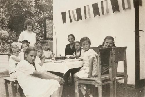 Zwart-witfoto van kinderen in tuin van het het Rietveld Schröderhuis, met slinger en lampion
