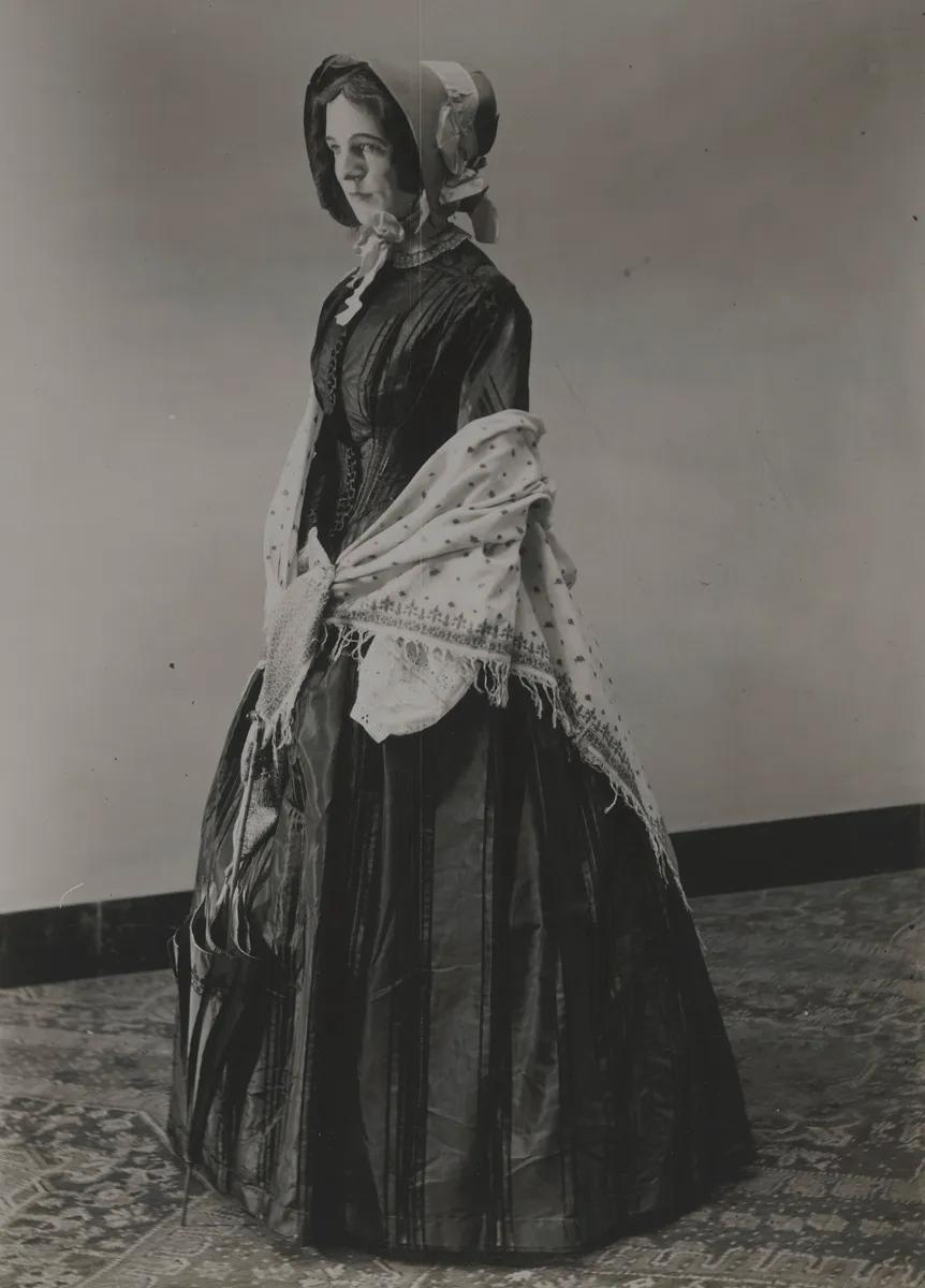foto uit 1947 van vrouw in groene tafzijden jurk
