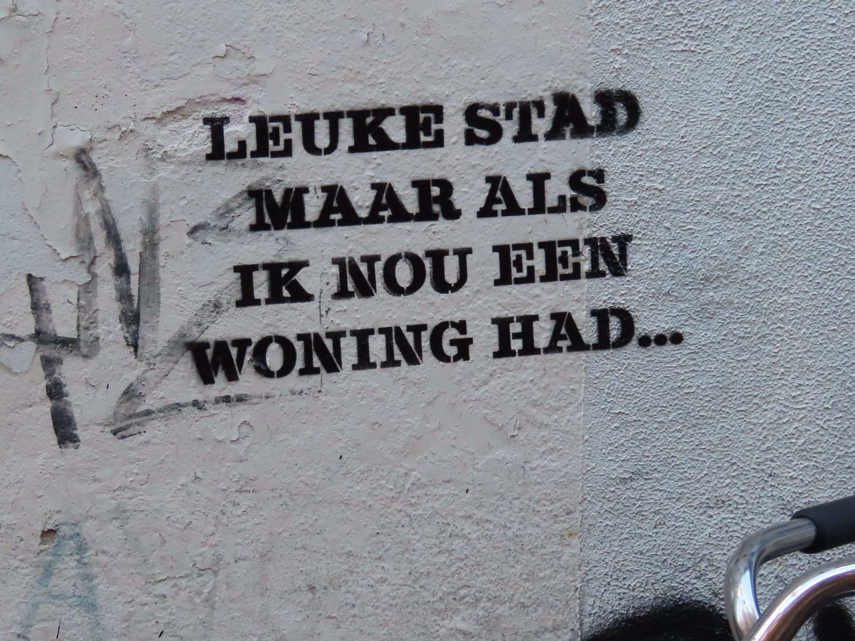 Een afbeelding van een muur met de tekst 'leuke stad maar als ik nou een woning had.."