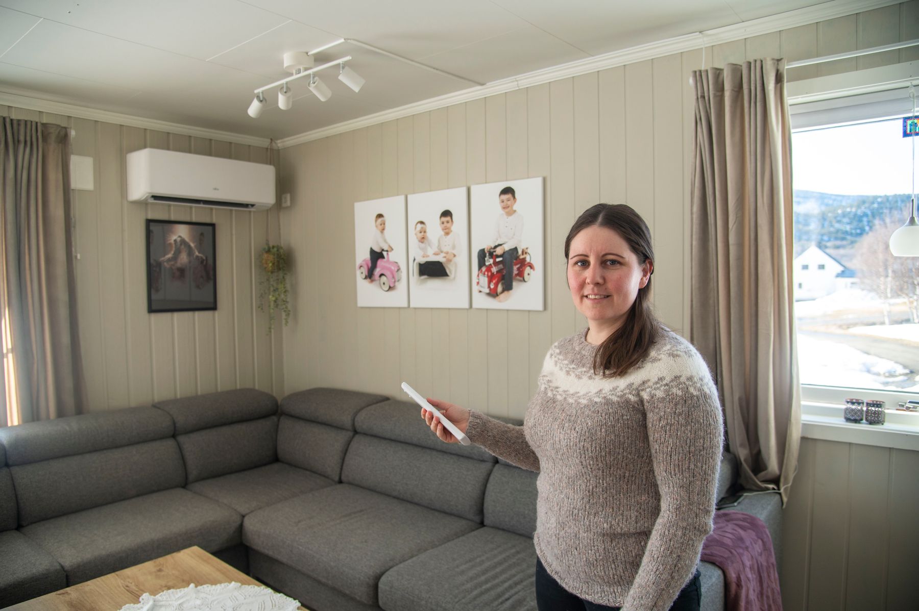 Marlene peker på varmepumpa si med fjernkontrollen