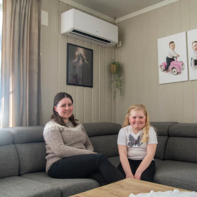 Marlene Gundersen sitter i sofen sammen med sin datter