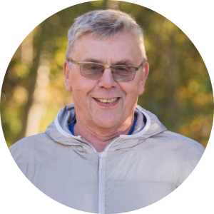 Smilende, eldre mann i grå jakke står utendørs og smiler mot deg. Han har briller og kort hår. Idar jobber på kundeservice i Ishavskraft som seniorrådgiver.