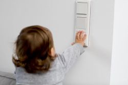 Barn trykker på en lysbryter som nylig ble skiftet av elektriker.