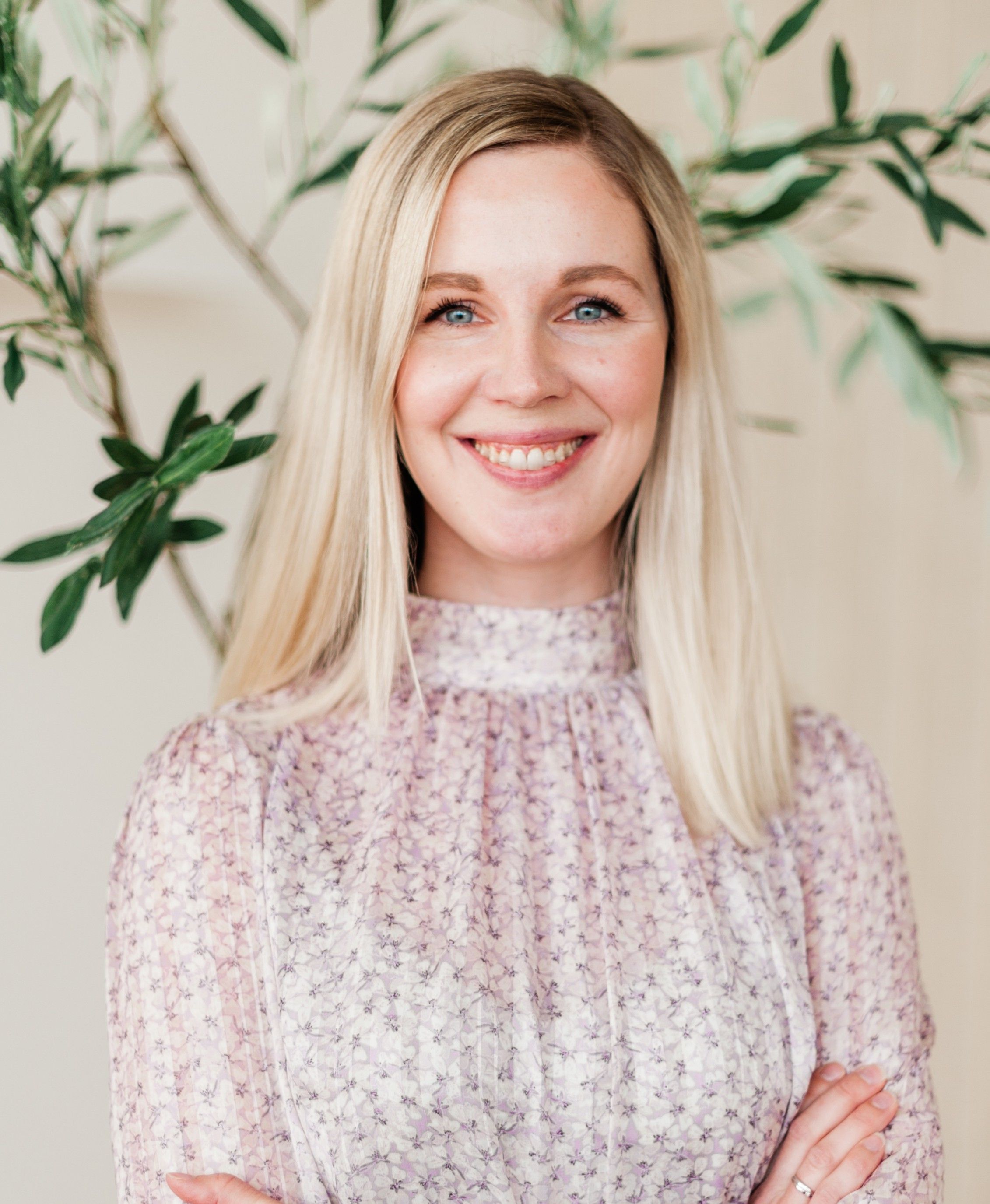 Kvinne står på et lyst og moderne kontor, hun står med armene i kryss og smiler mot kameraet – sjekk om du kan få en bedre strømavtale ved å sende oss fakturaen din