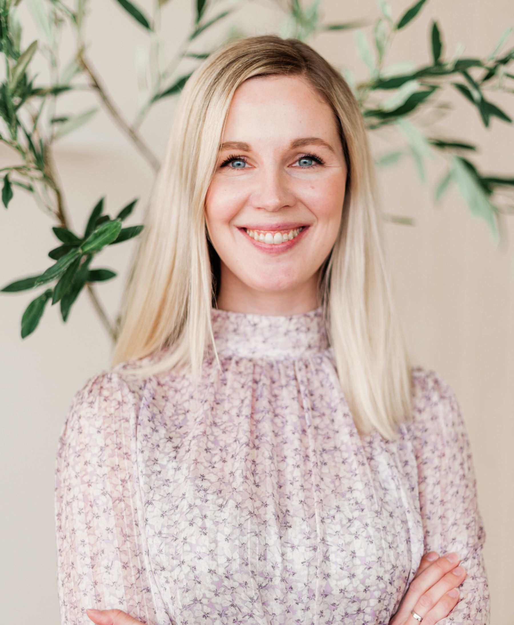 Kvinne står på et lyst og moderne kontor, hun står med armene i kryss og smiler mot kameraet – sjekk om du kan få en bedre strømavtale ved å sende oss fakturaen din