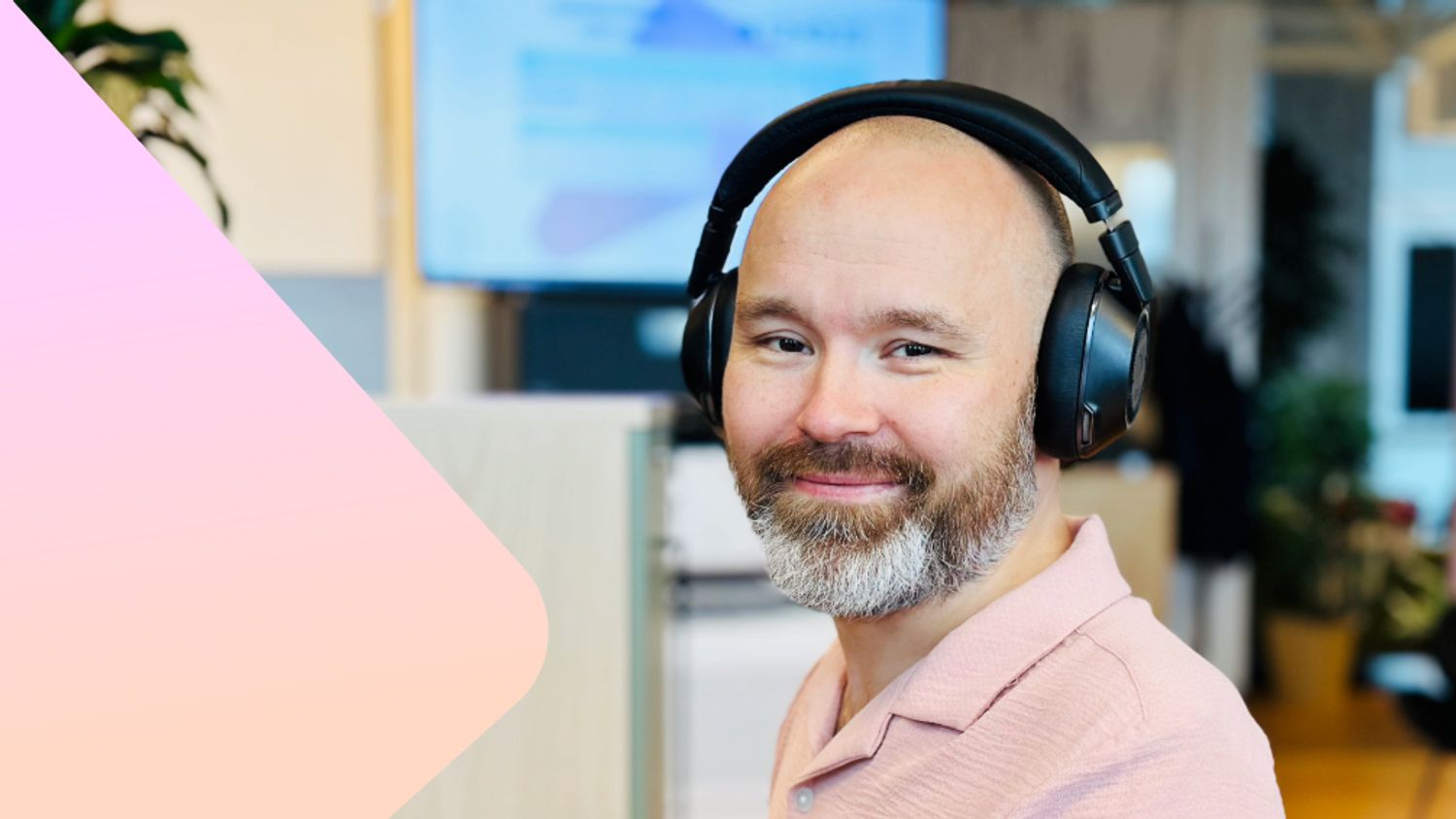 Kunderådgiver hos Ishavskraft, Eskil, smiler mot kamera. Han sitter i Ishavskrafts kontorlandskap og har på seg en lakserosa skjorte. I bakgrunnen kan man skimte skjermer med data.