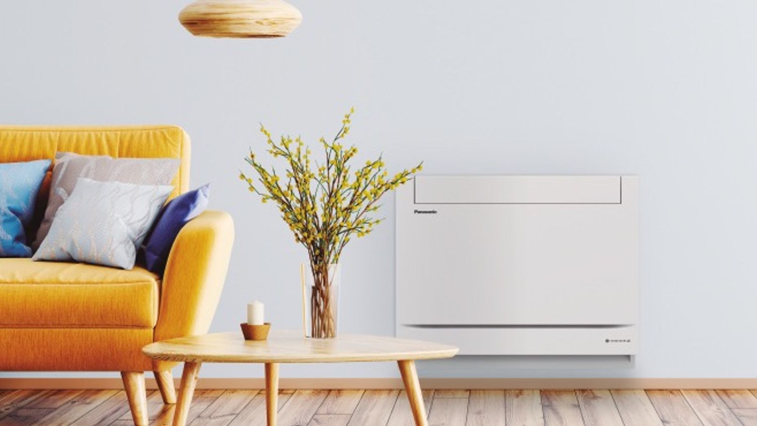 Hvit Panasonic Gulvmodell (Z25UFEAW) fra Ishavskraft, montert lavt på en stuevegg ved siden av en gul sofa og trebord