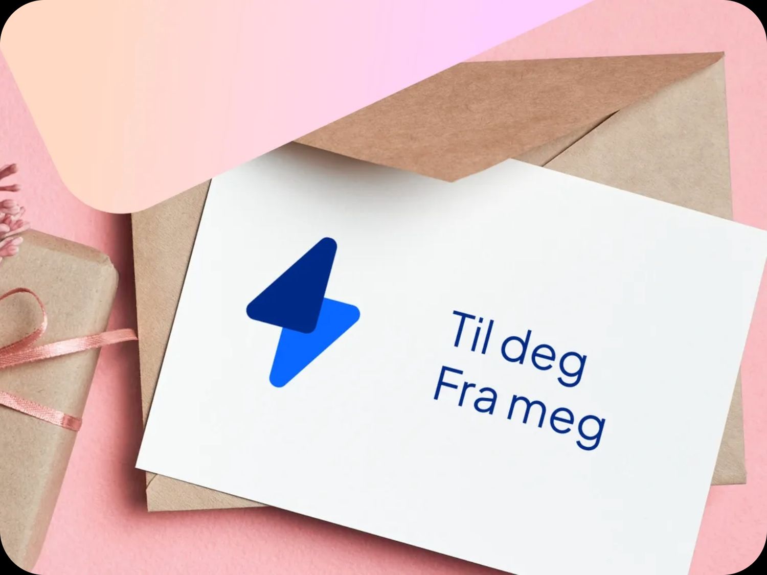 Eg gavekort på strøm med teksten til deg fra meg. Kortet ligger oppå en konvolutt, og ved siden av ligger det en pakke i gråpapir med rosa silkebånd. Bakgrunnen er rosa.