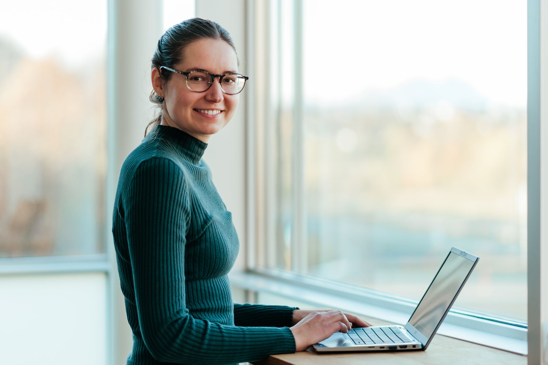 Julia Wagner, kundeanalytiker i Ishavskraft, er stolt over innsatsen husholdningene gjør. Her smilende foran PCen sin.