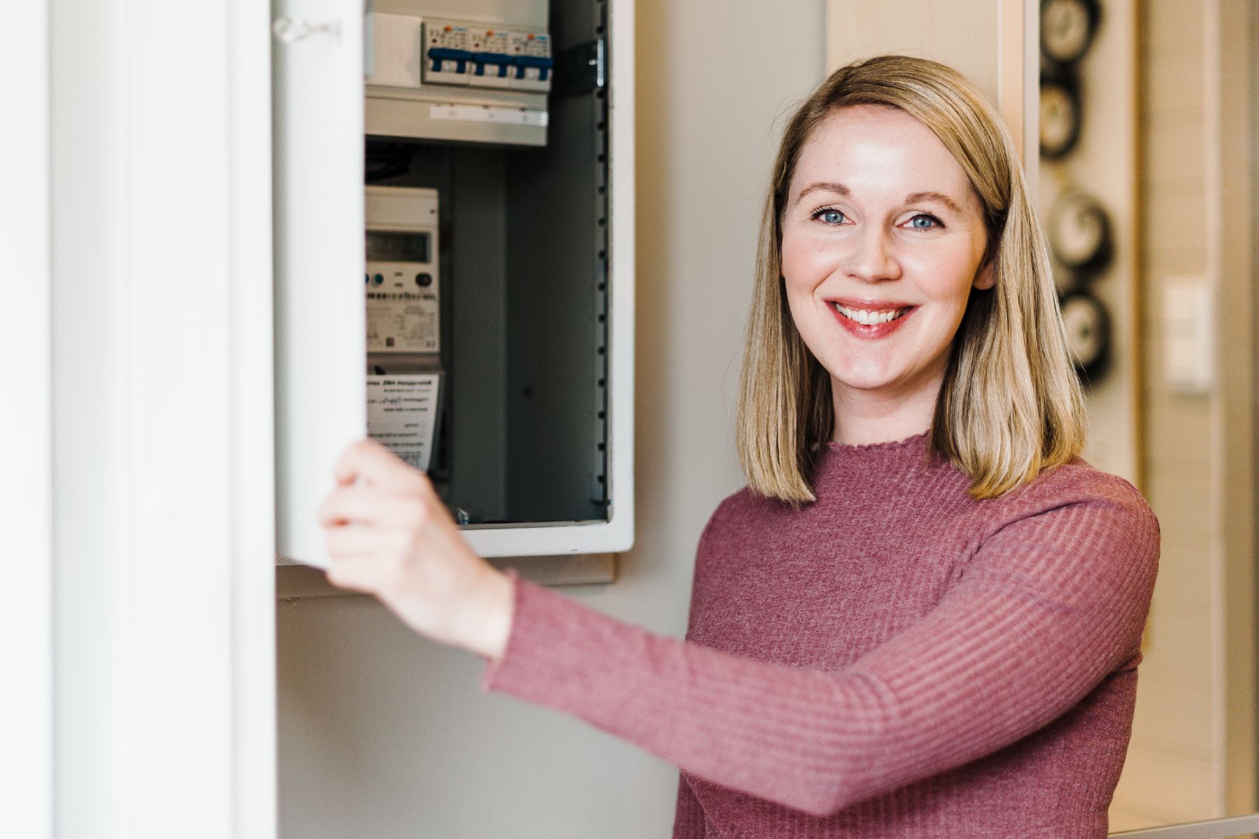Oppgradering av sikringsskapet er viktig for tryggheten i hjemmet. Gravide Mari står ved siden av et moderne sikringskap.